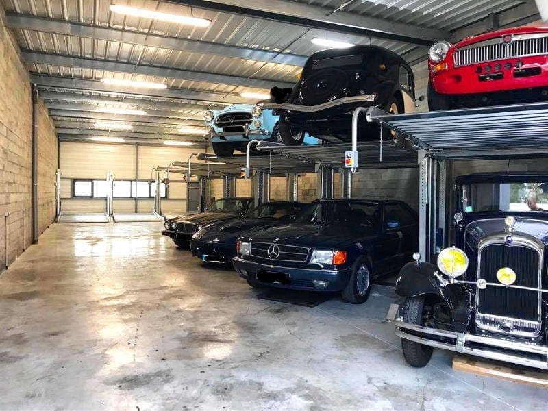 garaje con sistema duplicador de aparcamiento con coches aparcados en dos niveles